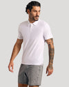 Model in The Staple Active Polo, white, with athletic shorts.