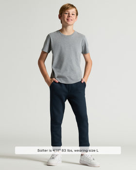 Boy modeling Boys' Classic Curved Hem Crew Neck, grey T-shirt, navy joggers.