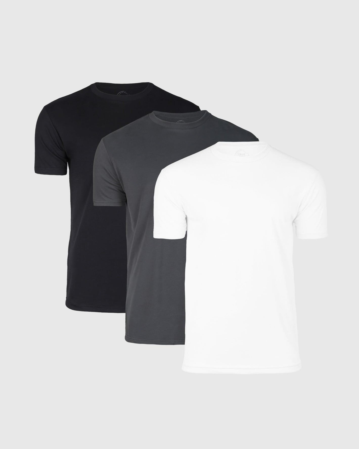 Three crew neck t-shirts in a pack, colors black, gray, and white, displayed in a stacked layout.