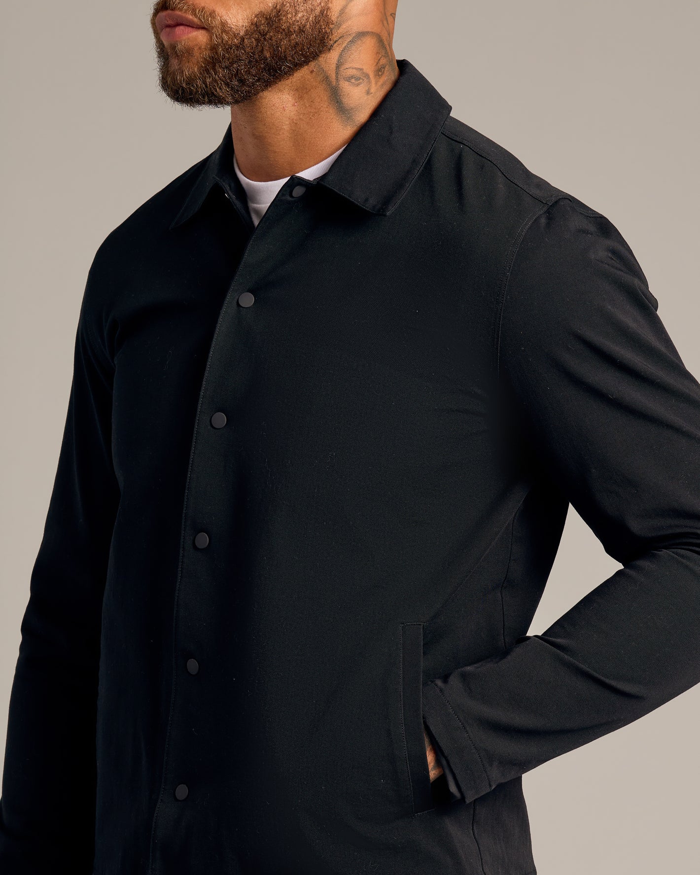 Black Coaches Jacket with snap buttons, worn over a white T-shirt.