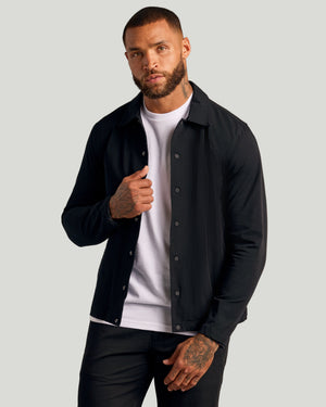 Black Coaches Jacket on young man, showcasing slim fit and snap closure.