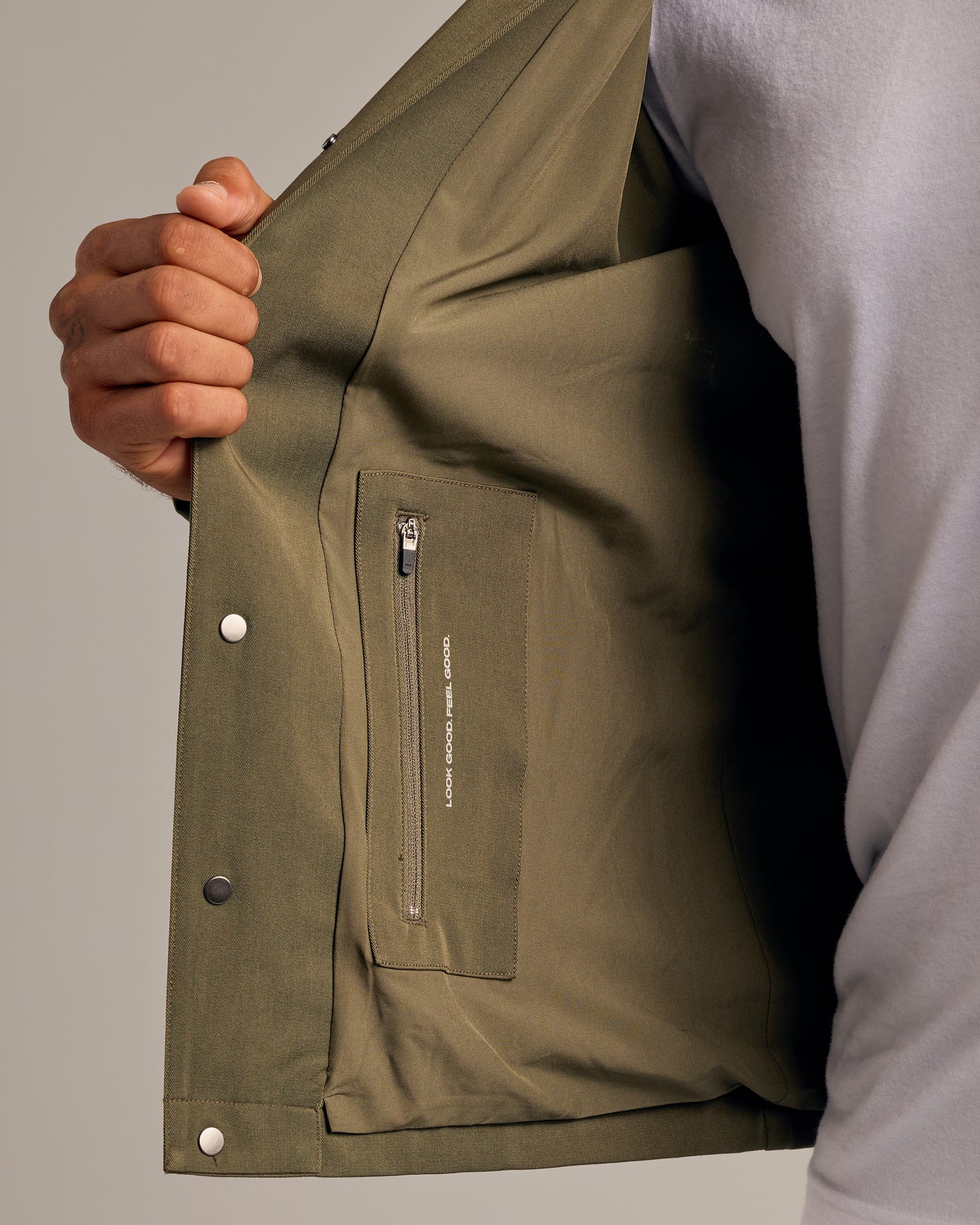 Military Green Coaches Jacket with interior zip pocket and snap-button closures.