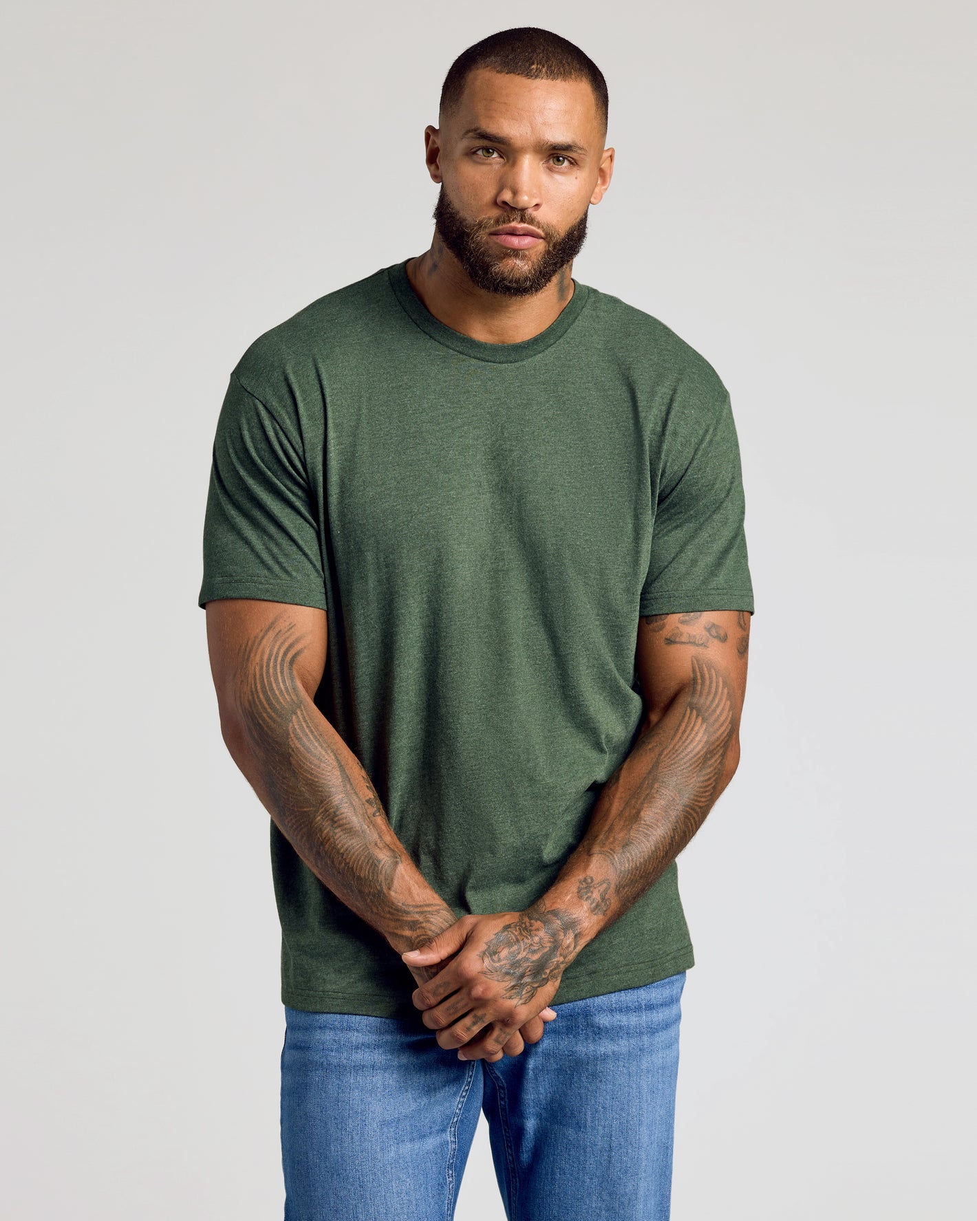 Man wearing CombinedListingTest Classic Crew Neck, arms by sides, tattooed forearms.