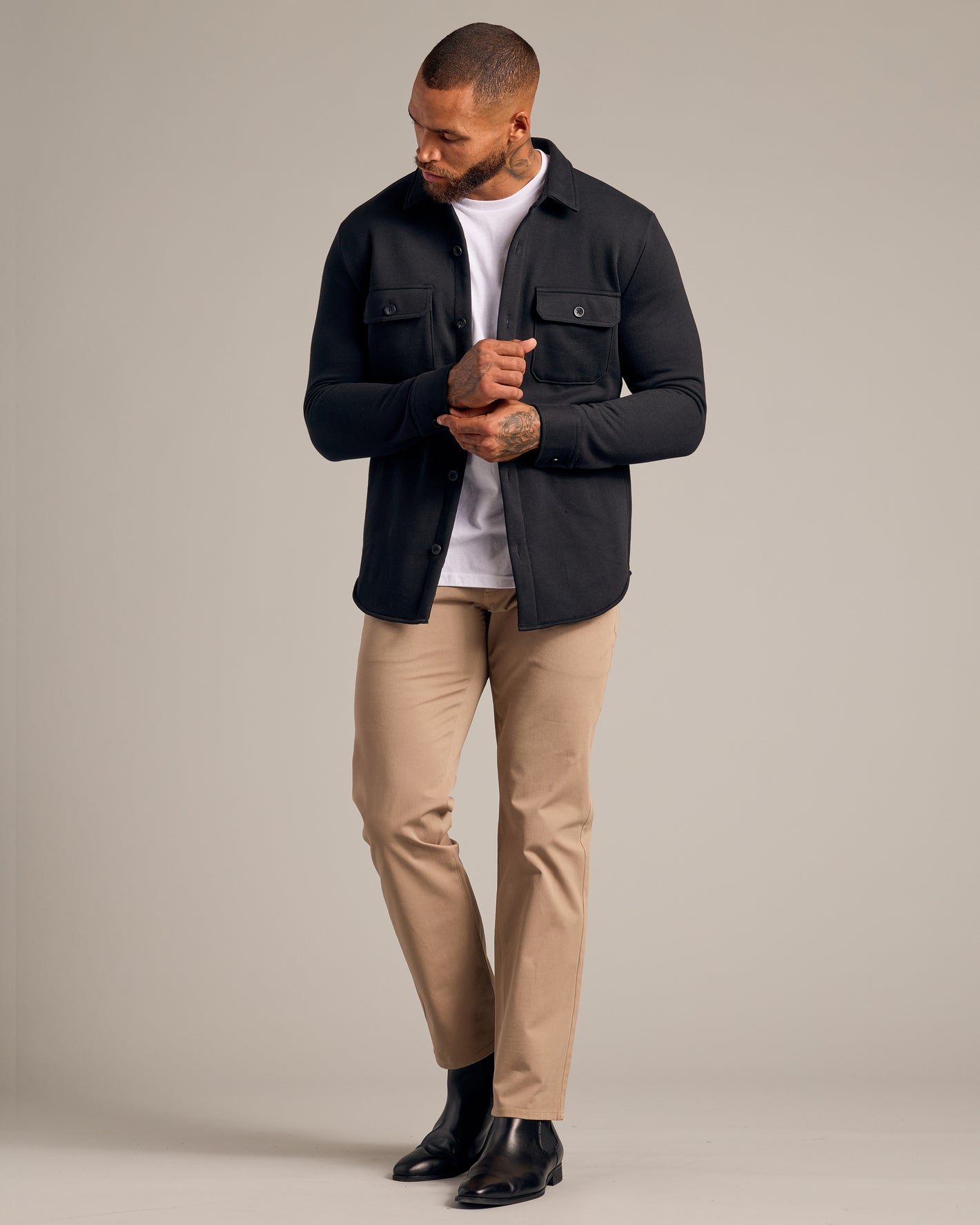 Black Fleece Shirt Jacket on model adjusting cuff, showcasing chest pockets.