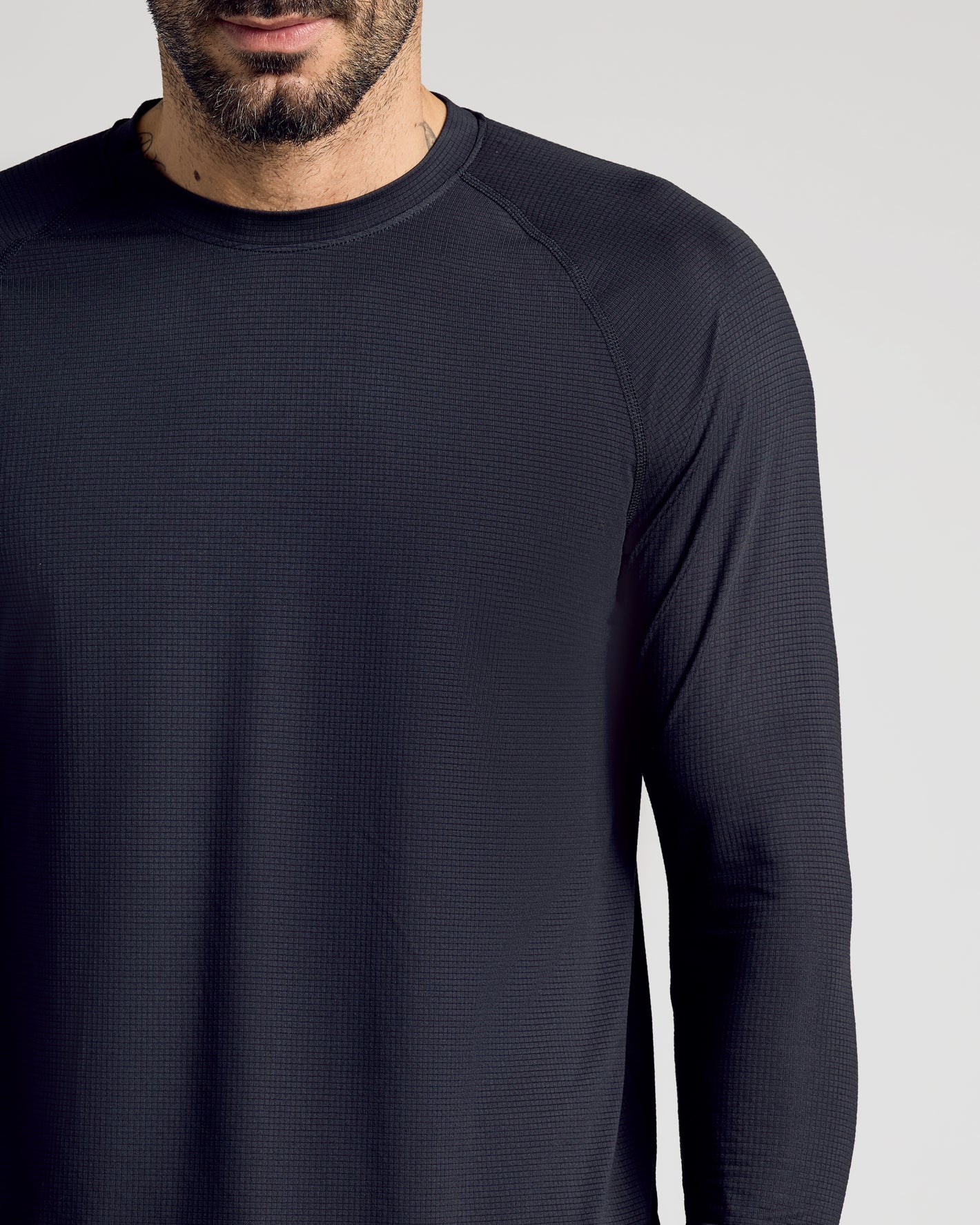 Man wearing Black Long Sleeve Active Mesh Crew, showcasing waffle-knit texture.