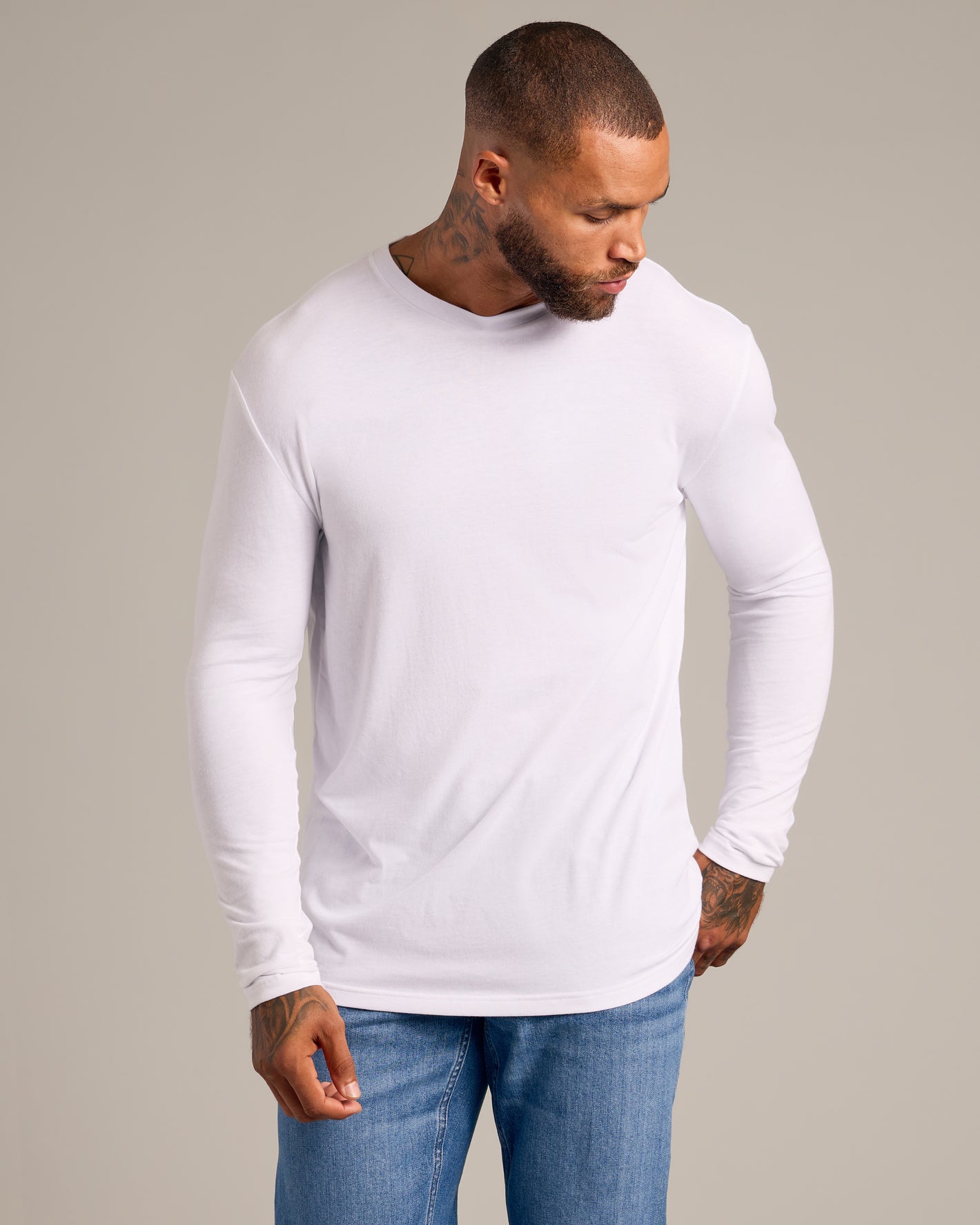 Model in Black & White Classic Long Sleeve Crew Neck 6-Pack, white shirt, blue jeans.