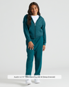 Child wearing Girls Deep Emerald Relaxed Joggers with hoodie and sneakers.