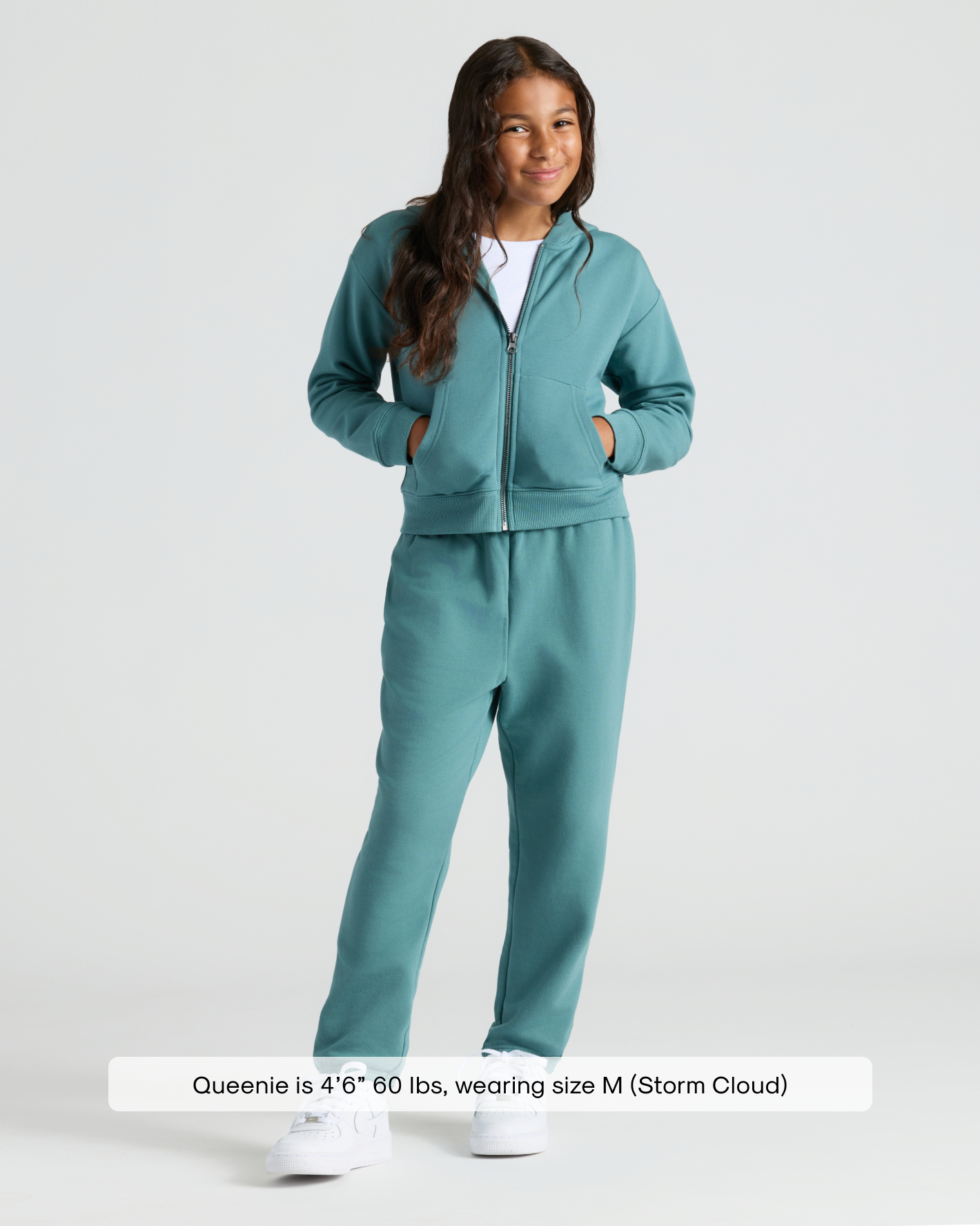 Girl in Girls Stormcloud Relaxed Joggers set, smiling, hands in pockets.