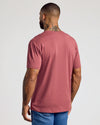 Man wearing Rustic Apple Classic V-Neck and blue jeans, back view.