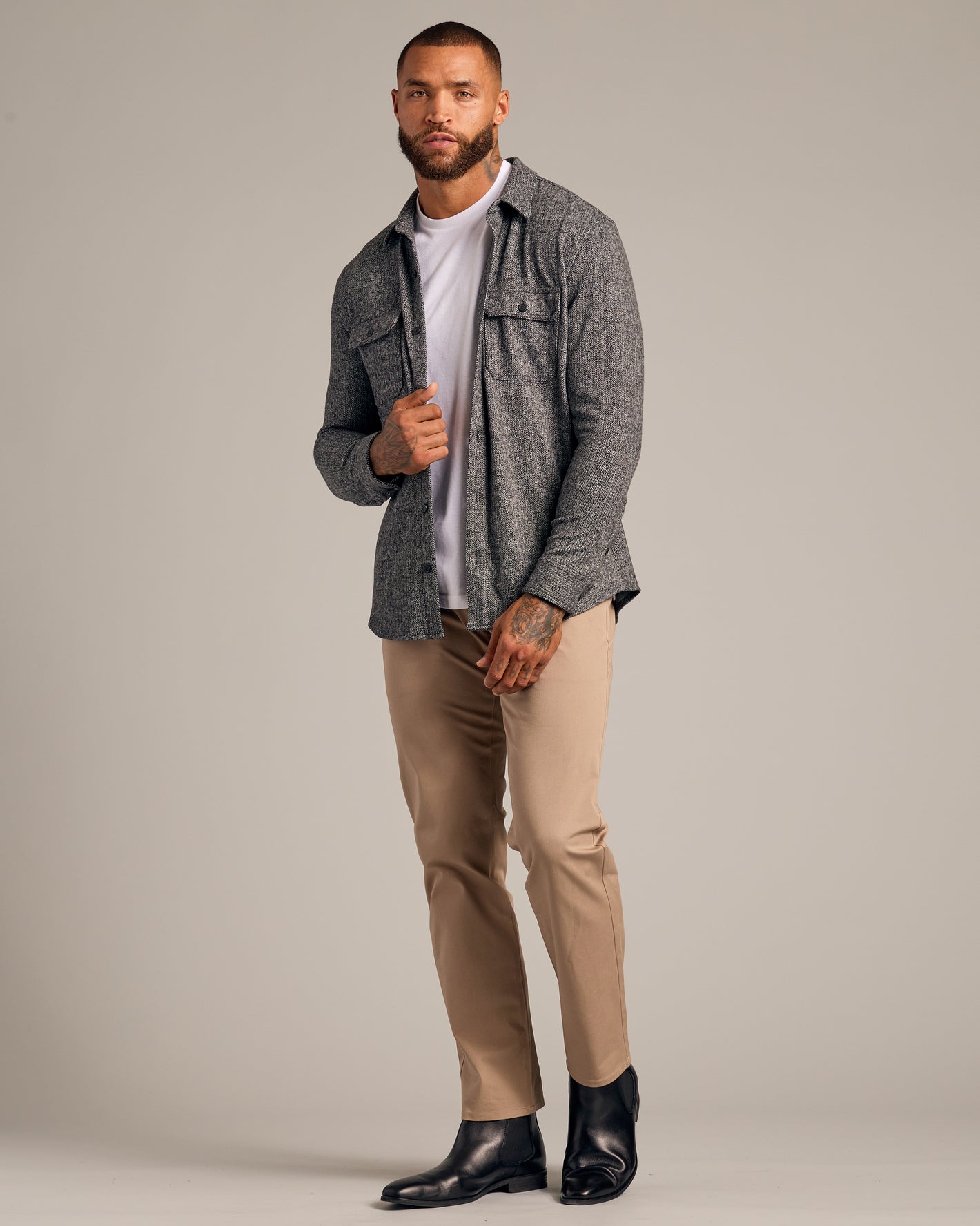 Male model in Black Sweater Shirt Jacket, white T-shirt, khaki trousers.