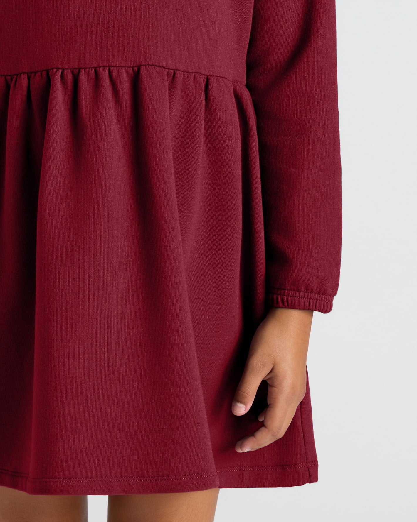 Girls Dark Maroon Long Sleeve Fleece Dress close-up, showing gathered waist and sleeve.