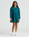 Girl in teal, long-sleeved fleece dress from Girls Dark Maroon & Deep Emerald Long Sleeve Fleece Dress 2-Pack.