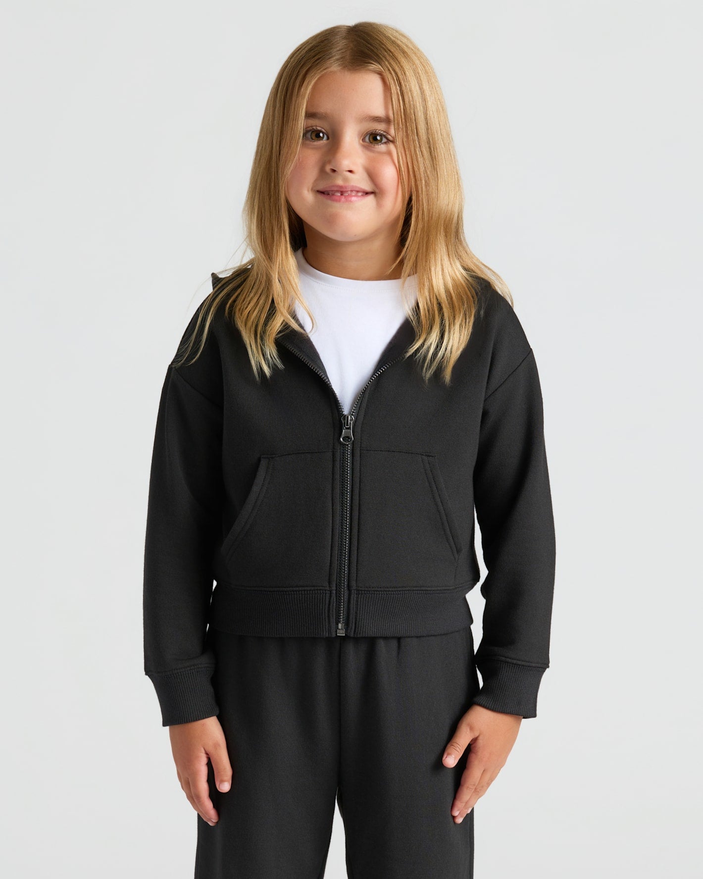 Girl wearing Girls Black & Stormcloud Cropped Zip Hoodie, smiling.