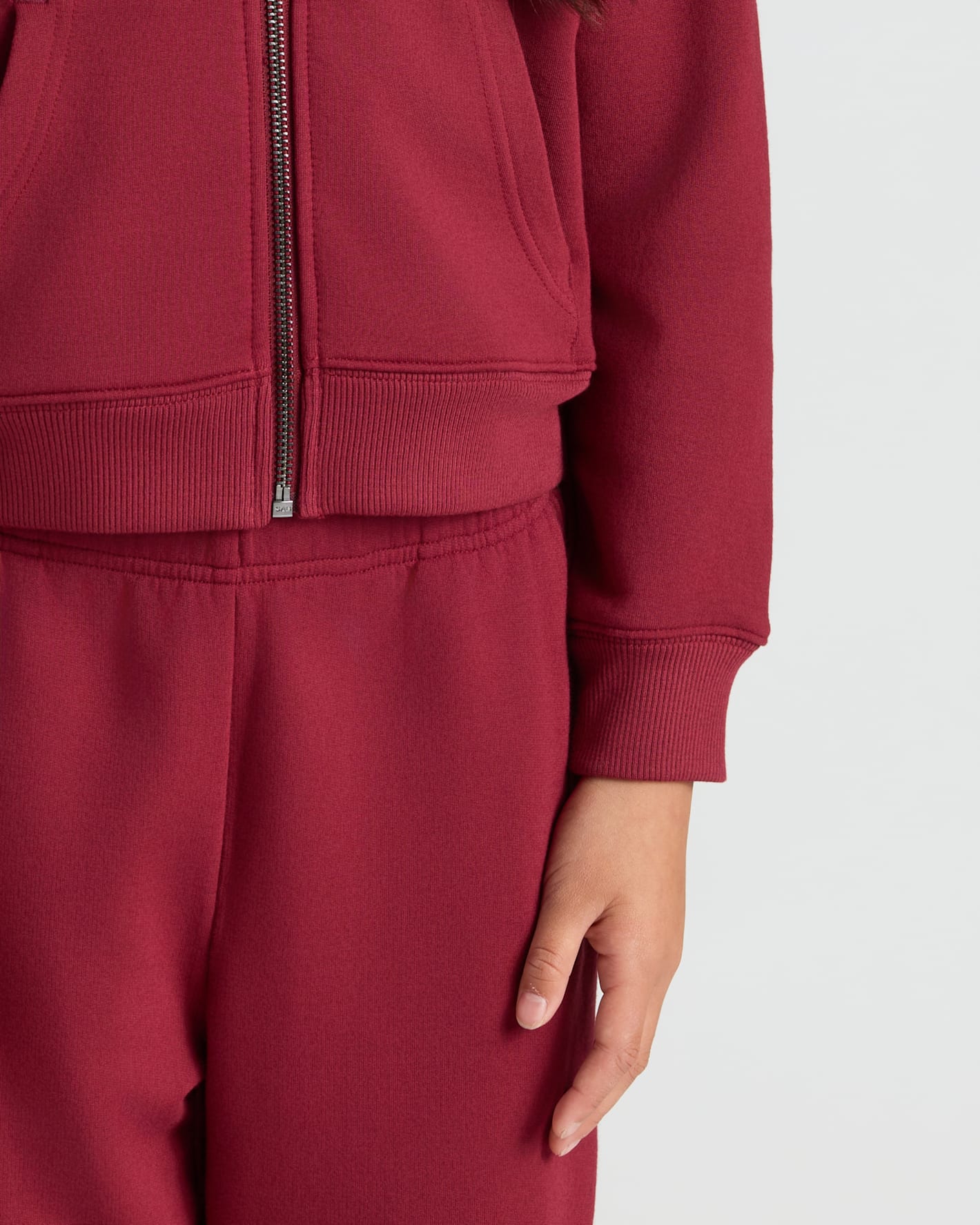Girls Dark Maroon Cropped Zip Hoodie with ribbed hem and kangaroo pocket.
