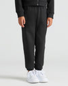 Child wearing Girls Deep Emerald & Black Relaxed Joggers, showing black joggers and white sneakers.