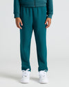 Girls Deep Emerald Relaxed Joggers with elastic cuffs and white sneakers.