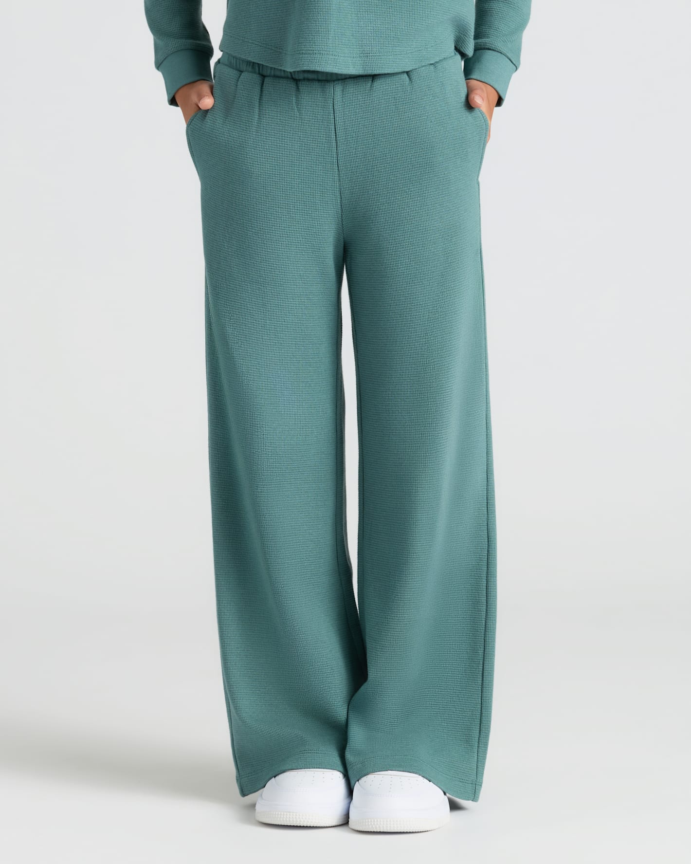 Girls Stormcloud Waffle Wide Leg Pants with pockets and white sneakers.