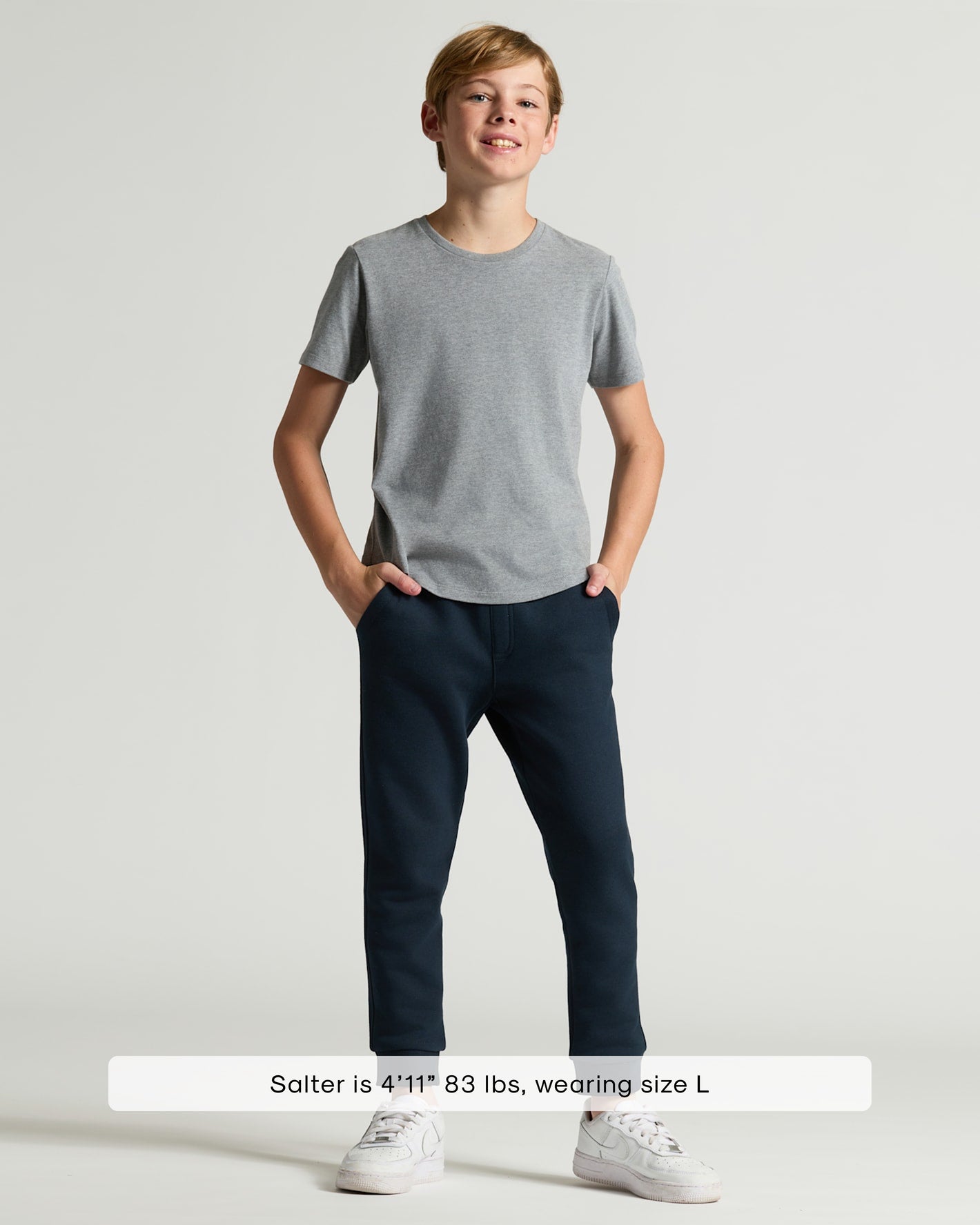 Boy wearing Boys' Heather Gray Classic Curved Hem Crew Neck with navy joggers.