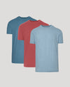 Three t-shirts in blue, red, and light blue on a gray background