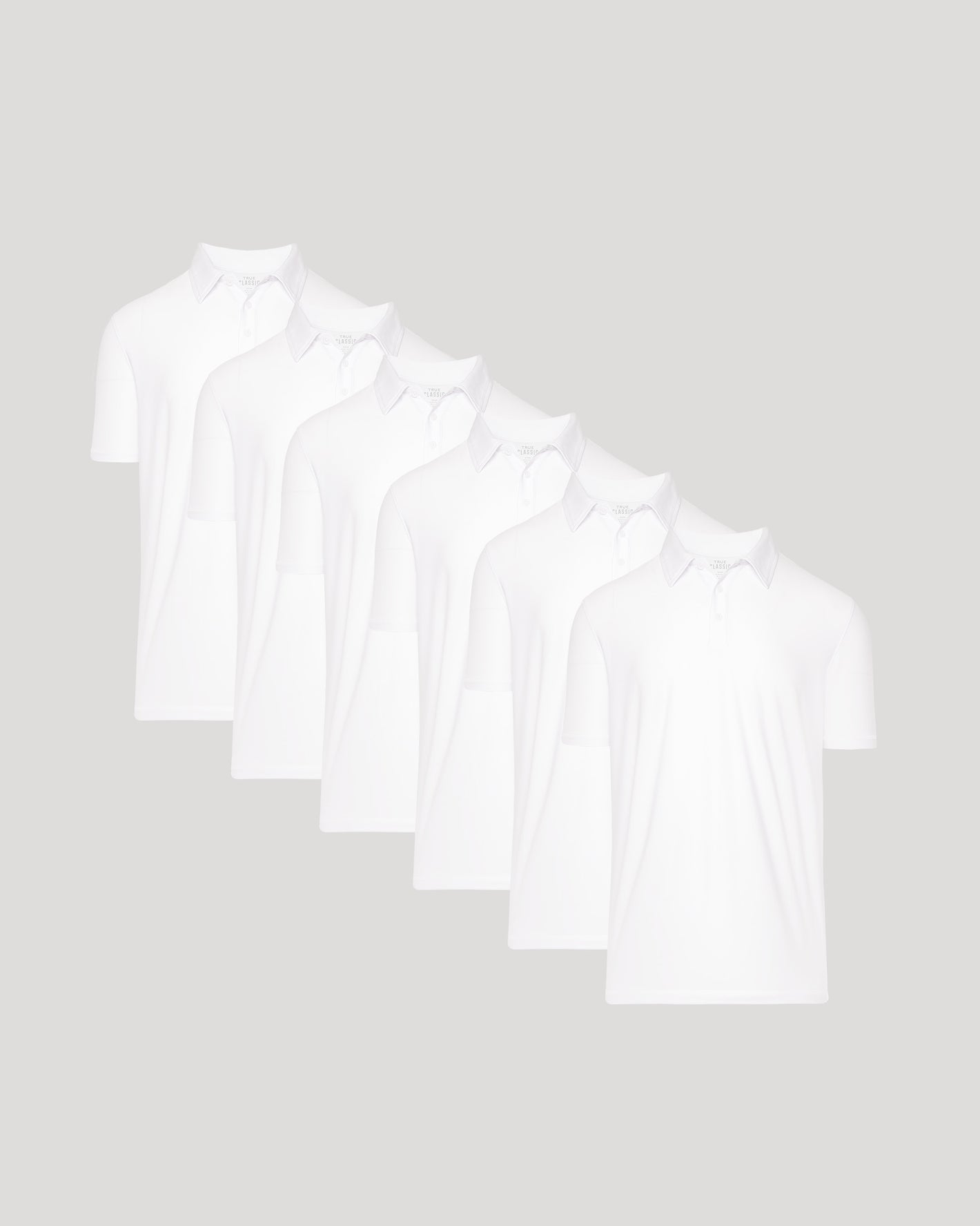 Five white t-shirts stacked on a light gray background