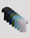 Six short-sleeve crew-neck t-shirts in different colors, arranged in a diagonal stack from back to front on a light gray background. The colors include black, charcoal, navy, olive green, sky blue, mint green, and light lavender.