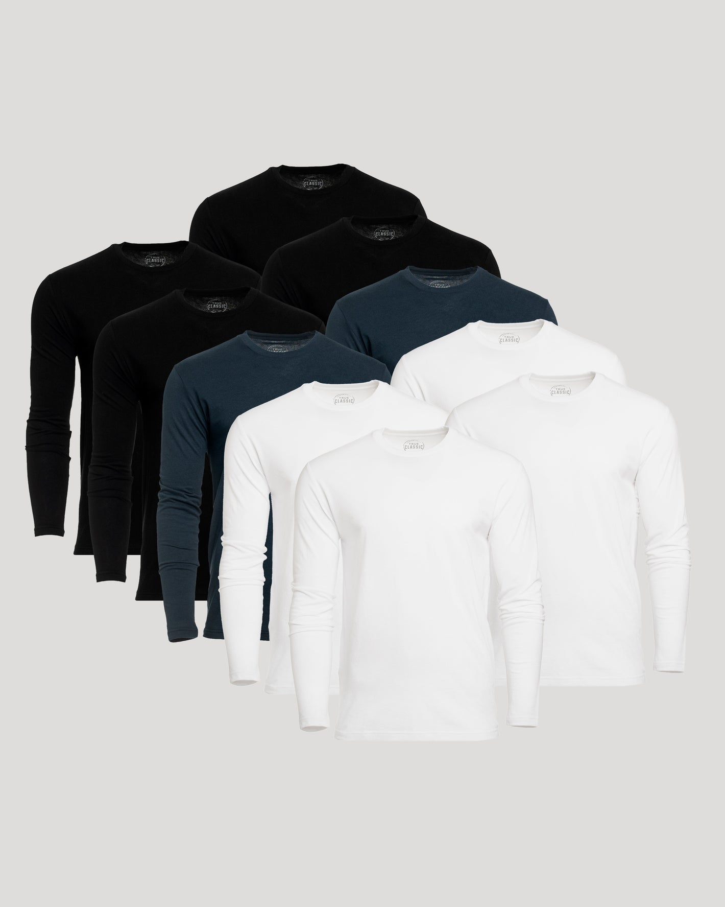 Set of black, navy, and white long-sleeve shirts on a light gray background