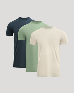 True ClassicThree plain t-shirts in navy, green, and beige on a light gray background
