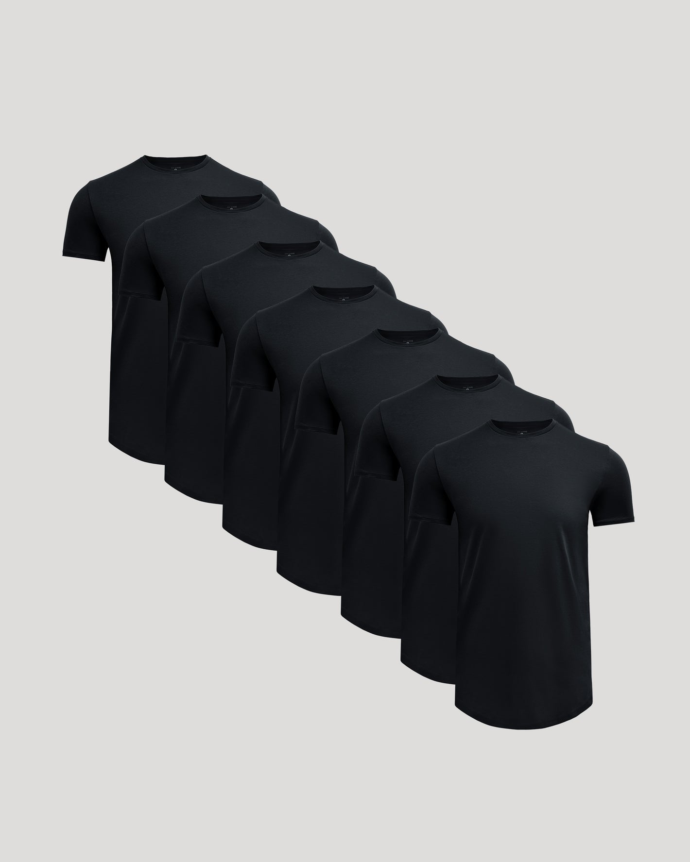 Seven black crew neck t-shirts arranged in a staggered row, showcasing the Tall Pima Cotton Blend Curved Hem Crew 7-Pack, designed as men's basics with a comfortable fit.