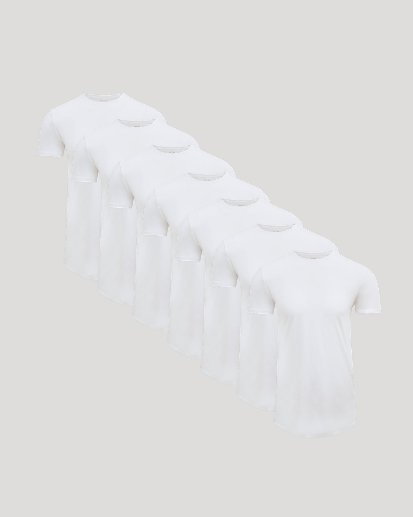 Seven white crew neck t-shirts arranged in a row showcasing the Tall Pima Cotton Blend Curved Hem Crew 7-Pack, a men's basics essential for comfortable everyday wear.