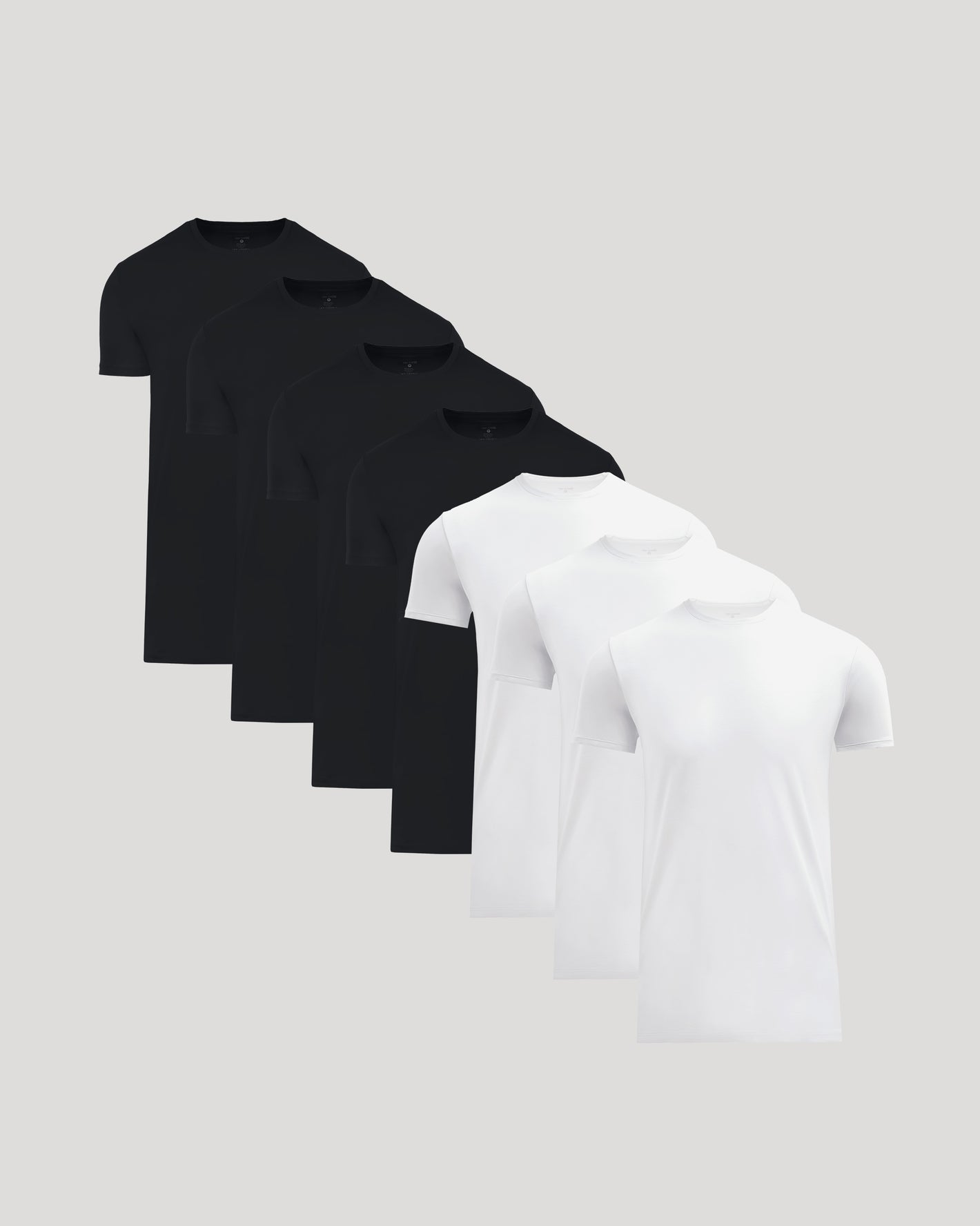 Seven men's basic crew neck t-shirts in black and white, arranged in a staggered row showcasing the Tall Pima Cotton Blend Crew 7-Pack.