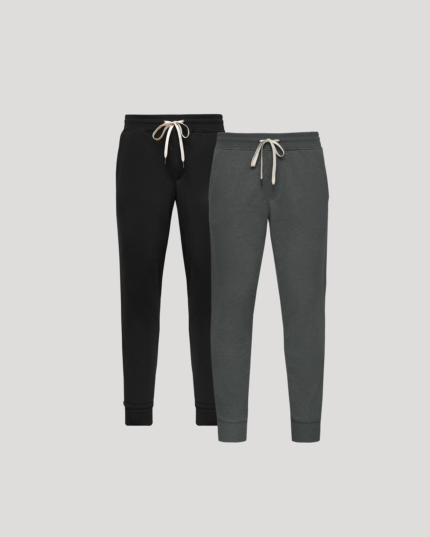 Navy and gray sweatpants with drawstrings on a light gray background