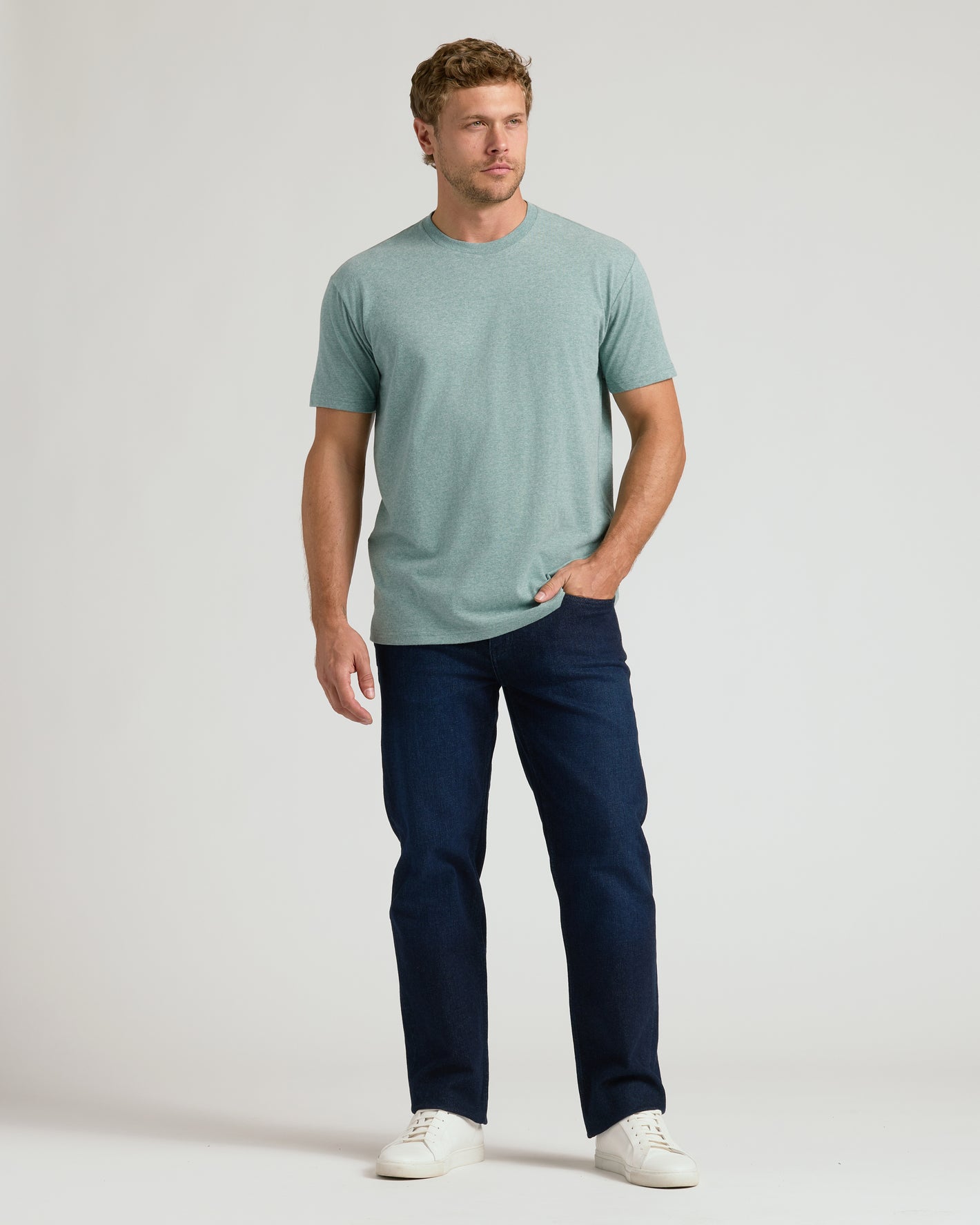Man in Heather Balsam Classic Crew Neck, jeans, sneakers.