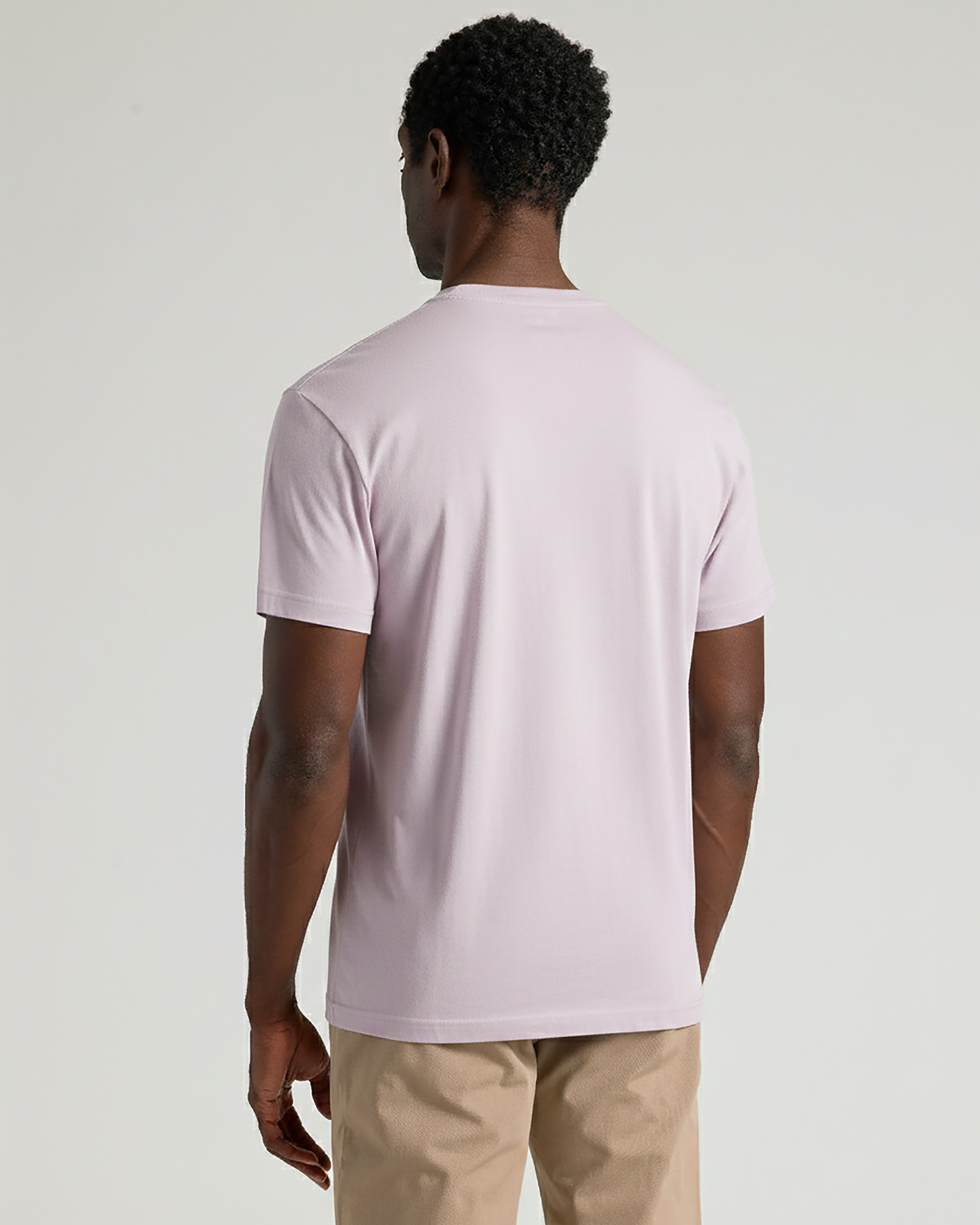 Person wearing a light purple t-shirt on a plain background