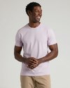 Man wearing a light purple t-shirt against a plain background