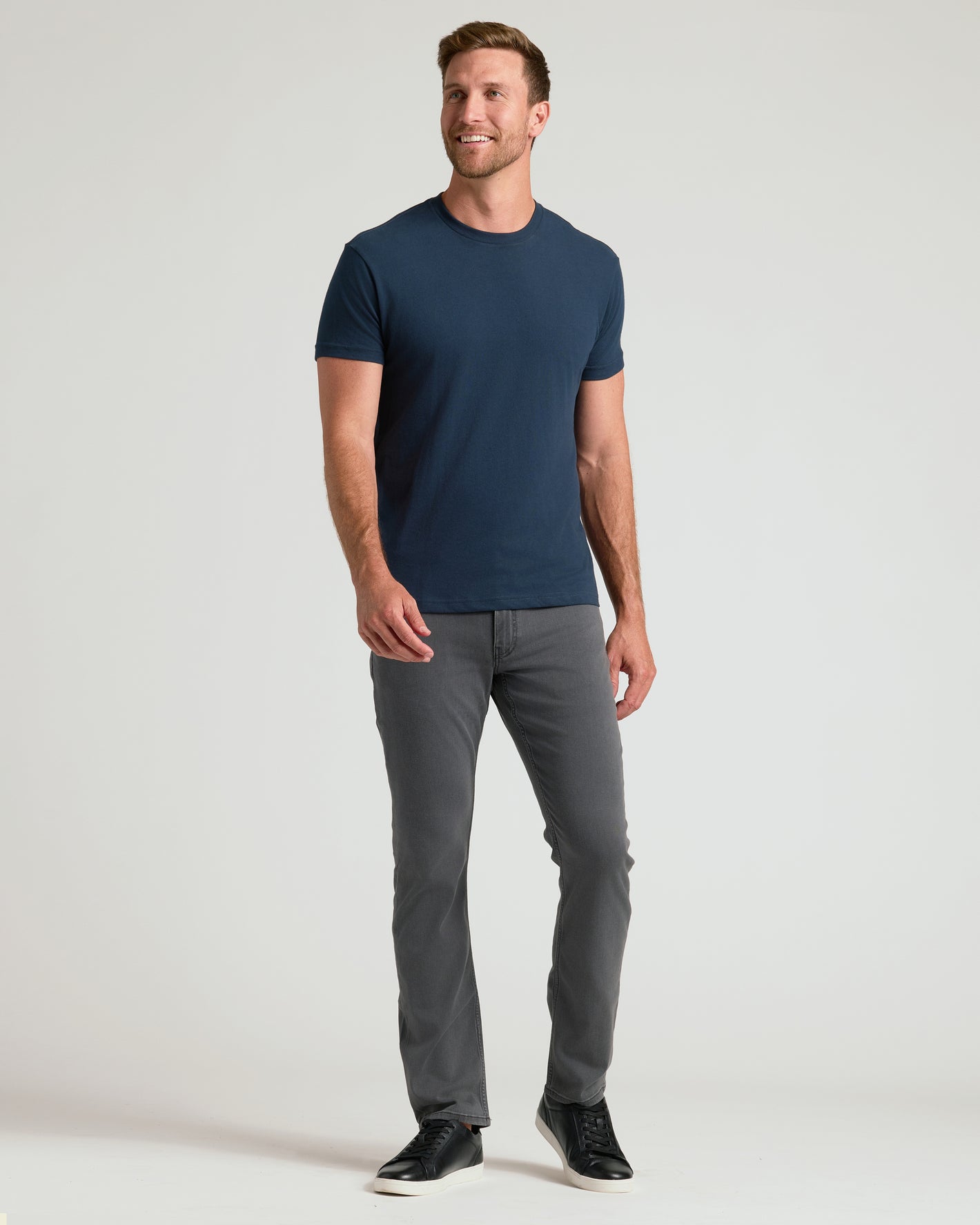 Man in navy Classic Crew 10-Pack T-shirt, gray jeans, black sneakers.