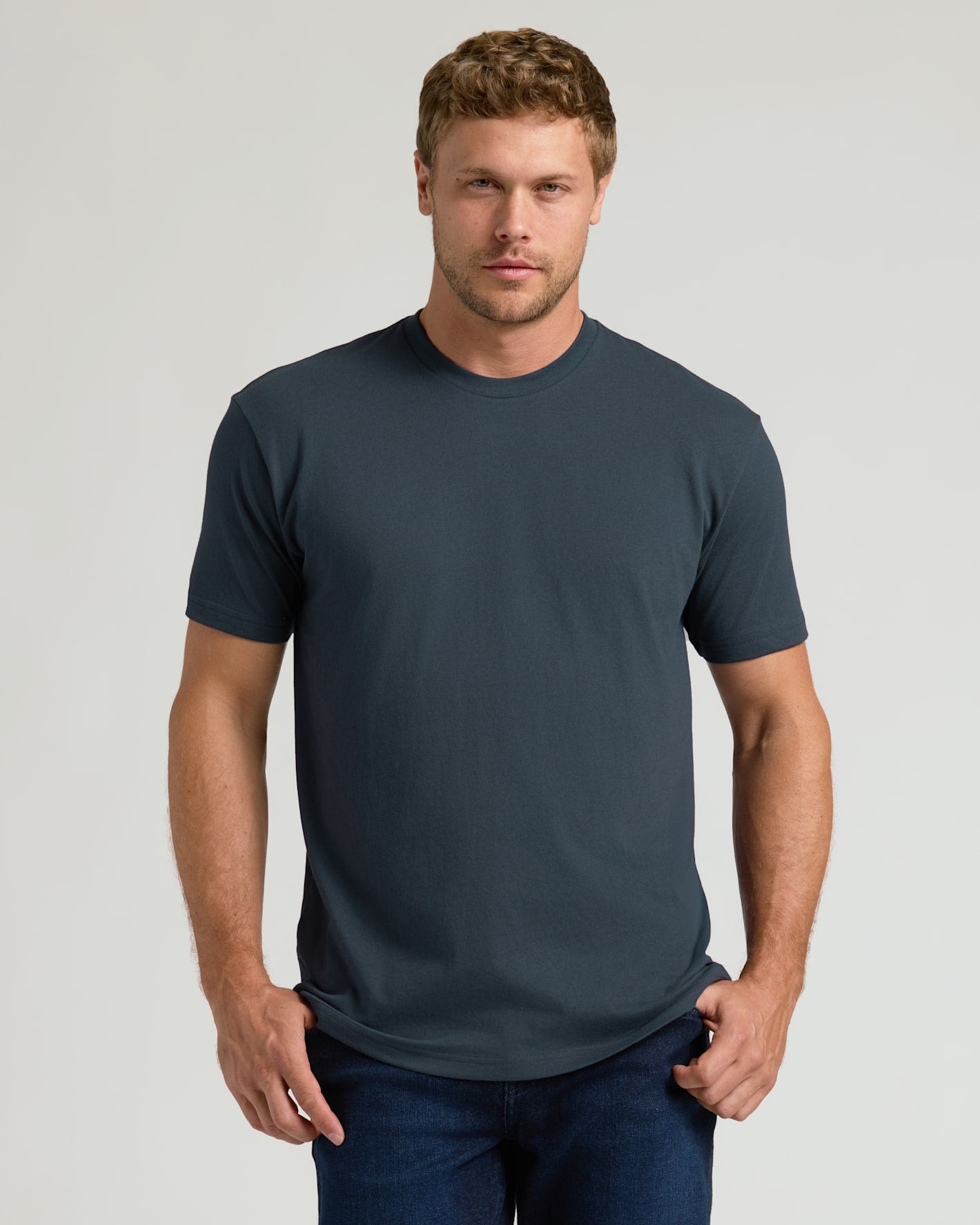 Man wearing a dark gray t-shirt against a light gray background