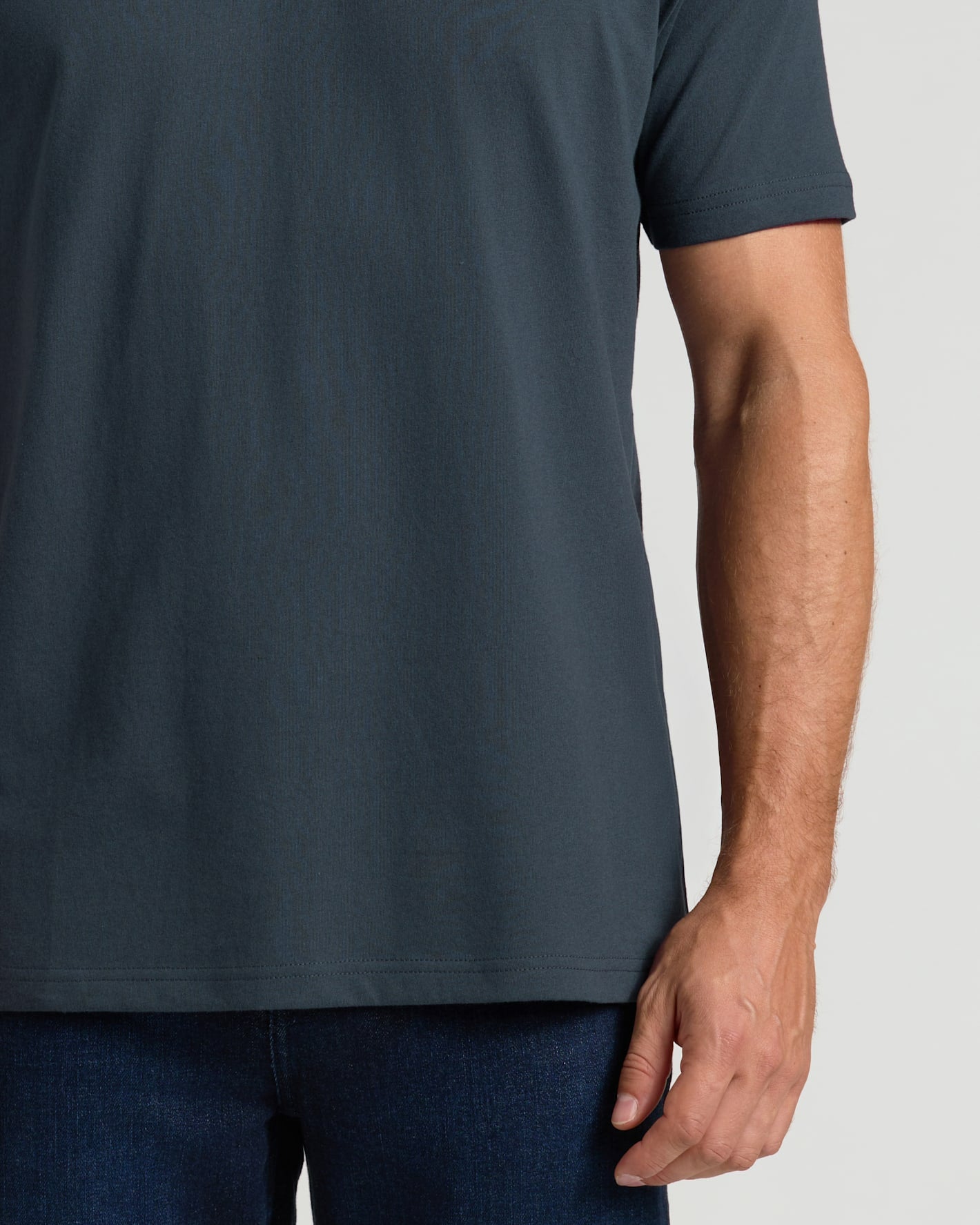 Person wearing a dark gray t-shirt on a light gray background