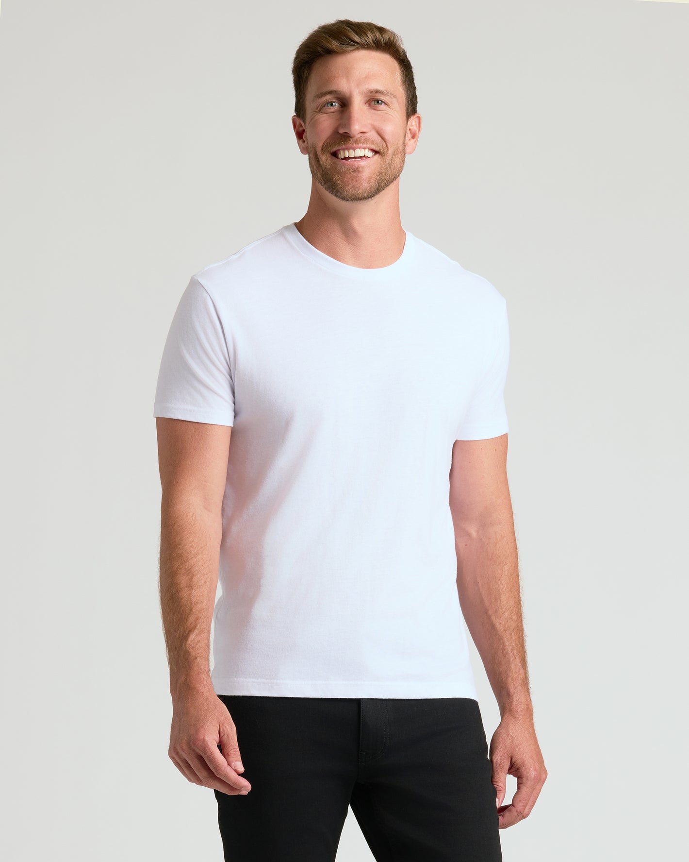 Man wearing a plain white t-shirt against a light gray background