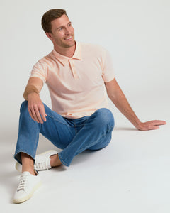 True ClassicMan wearing Coral Blush Classic Polo, seated casually, smiling.