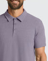 Man wearing Dark Heather Amethyst Short Sleeve Polo, smiling, showcasing its fit.