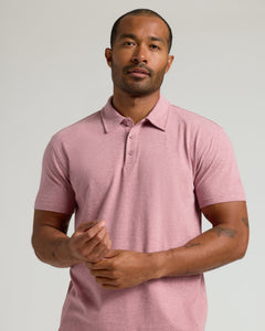 True ClassicMan wearing Light Heather Boysenberry Classic Polo, gesturing with tattooed forearms.
