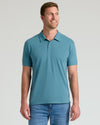 Man wearing Sapphire Classic Polo, teal short-sleeve with jeans, smiling.