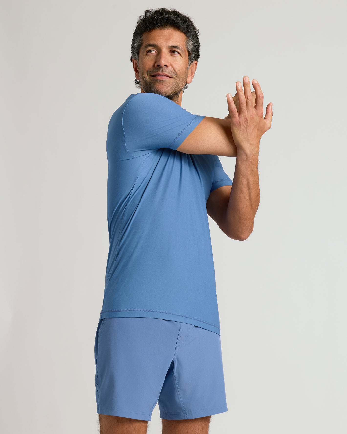 Man stretching in Azul Active Crew Neck Tee.