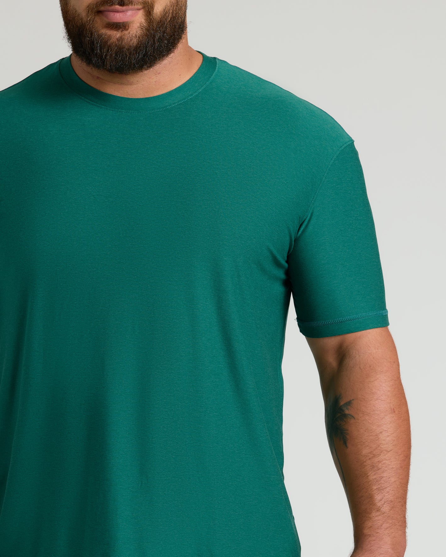 Clover Active Crew Neck Tee on bearded man in neutral setting.