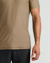 Close-up of a man's torso wearing a fitted Driftwood Active Crew Neck Tee in a neutral brown shade paired with black shorts, highlighting the smooth fabric and short sleeves.