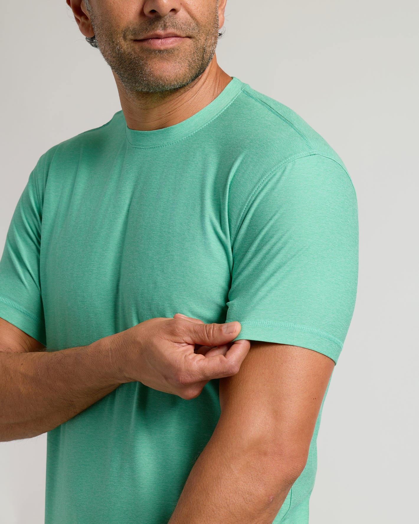 Fern Active Crew Neck Tee worn by man adjusting sleeve.