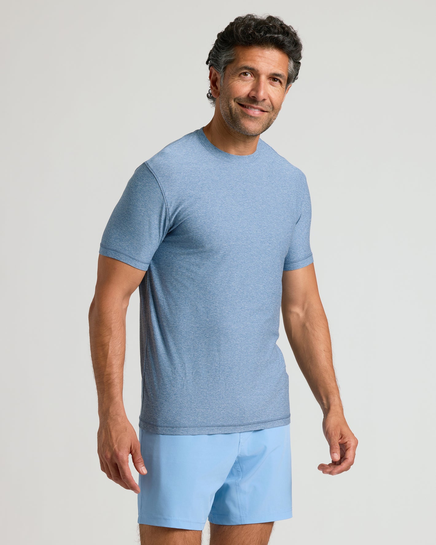 Man wearing Heather Azul Active Crew Neck Tee, looking at the camera.