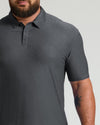 Close-up of a man wearing a charcoal heather gray short-sleeve polo shirt with a three-button placket, showing the Charcoal Heather Gray Active Polo 2.0 design.