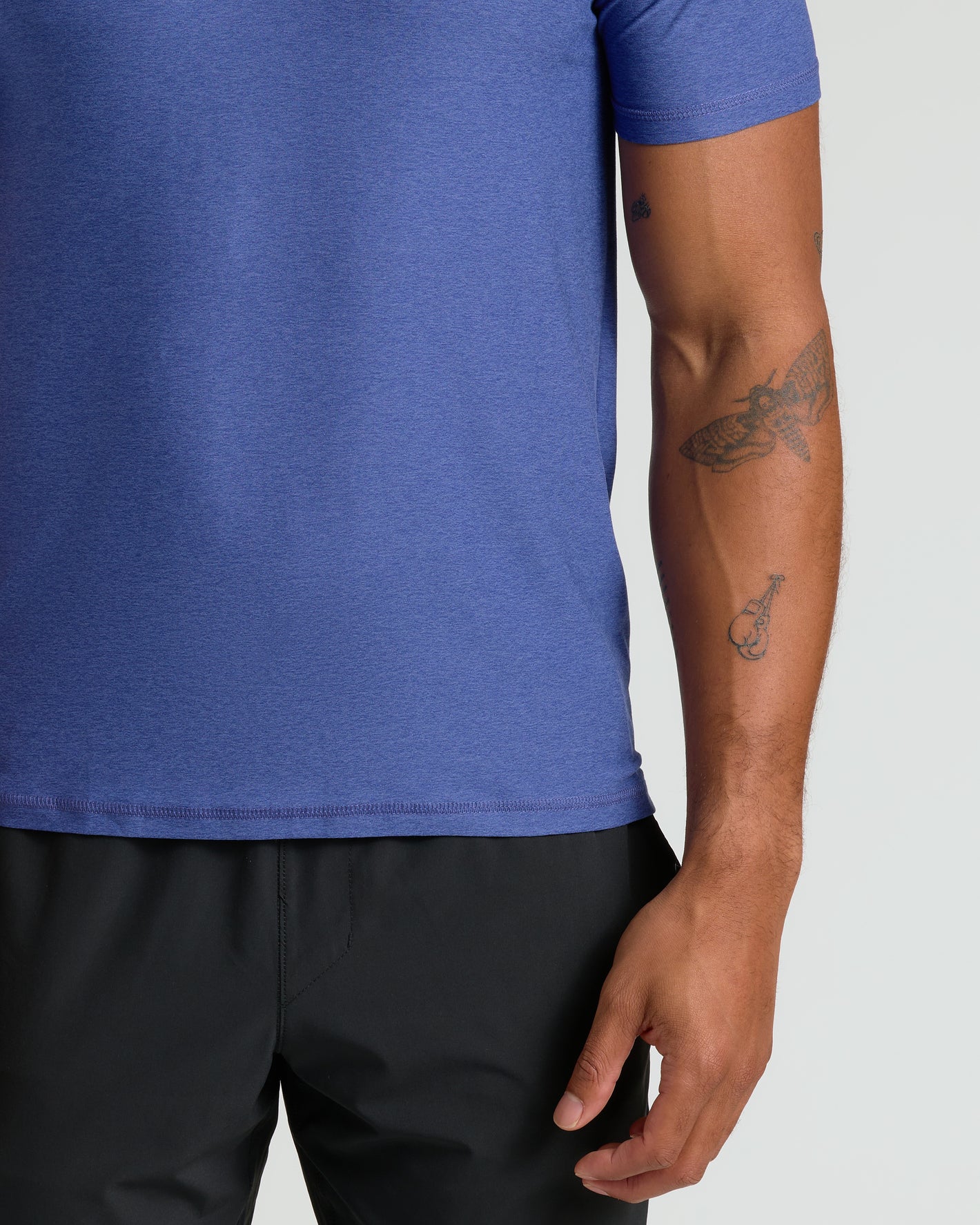 Cosmos Active Polo 2.0 with tattoos visible on forearm.