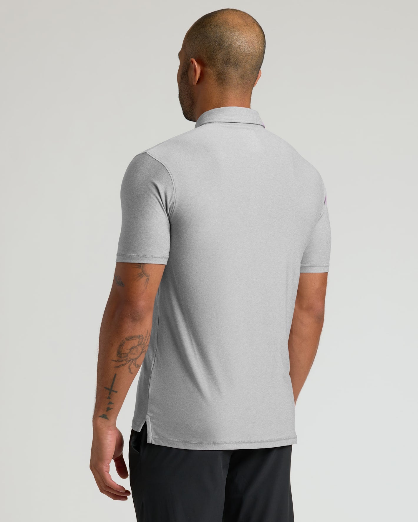 Man wearing a Light Heather Gray Active Polo 2.0 shown from the back, featuring short sleeves and a classic collar, highlighting a smooth and fitted design for men's basics.